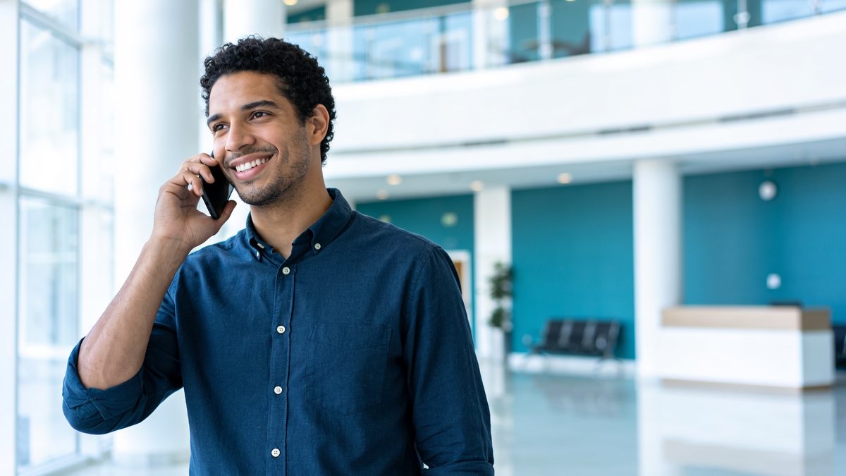 Profissional falando ao celular em ambiente corporativo